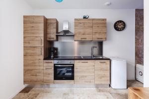 a kitchen with wooden cabinets and a sink at Romance Bleue -Love Room -SPA privatif - Netflix -séjour à vichy in Vichy +15 photos