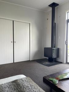 un salon avec une cheminée et un poêle dans l'établissement Ocean Shores Warea, 