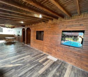 una habitación con pared de madera y piscina en Aconchego da Praia, en Imbituba