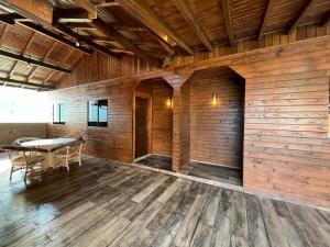 Una habitación con una mesa y una pared de madera. en Aconchego da Praia, en Imbituba