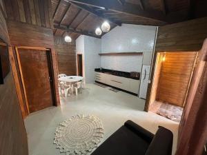 Una sala de estar con una mesa y una cocina. en Aconchego da Praia, en Imbituba