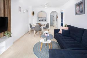 a living room with a blue couch and a table at Rinconcito de Catalina in Torrevieja