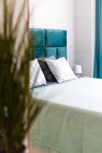a bed with a blue headboard and white pillows at Rinconcito de Catalina in Torrevieja