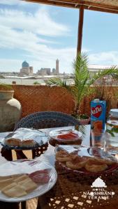 a table with plates of food on top at Hotel Naqsh-band Terrace in Bukhara