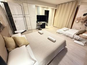 Una sala de estar con una cama blanca y un sofá. en La Suite N4 exclusive rooms, en Alghero