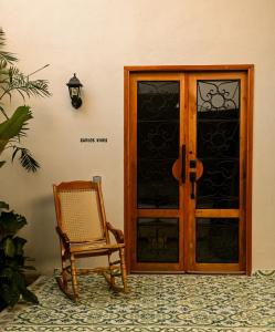 Hotel Libreria Cafe de Pombal في سانتا مارتا: باب خشبي مع كرسي بجوار الغرفة