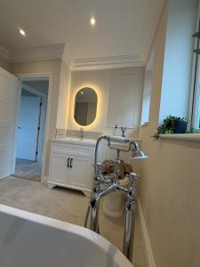 a bathroom with a white sink and a mirror at Stylish 3-Bed Home Close to Newcastle City Centre in Kenton +7 photos