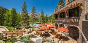an outdoor patio with tables and umbrellas in front of a building at 6th Floor Mountain View Room - Fireplace Suite in Tahoe City
