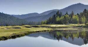 a golf course with a lake and mountains in the background at 6th Floor Mountain View Room - Fireplace Suite in Tahoe City