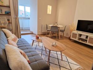 アヌシーにあるLe Petit Nid Annecyのソファとテーブルのあるリビングルーム