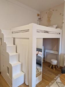 アヌシーにあるLe Petit Nid Annecyの白い二段ベッドが備わる客室です。