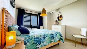 - une chambre avec un lit doté d'un couvre-lit tropical dans l'établissement Flamboyant Papeete, Great view, Chic and Comfort, à Papeete 13 autres photos