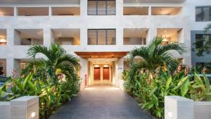 un bâtiment avec des palmiers devant dans l'établissement Flamboyant Papeete, Great view, Chic and Comfort, à Papeete