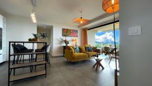 un salon avec un canapé jaune et une table dans l'établissement Flamboyant Papeete, Great view, Chic and Comfort, à Papeete