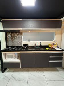 una cucina con lavello e fornello forno superiore di Loft lindo e aconchegante 02 a Toritama