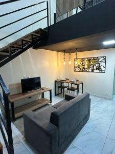 un soggiorno con un divano e un tavolo di Loft lindo e aconchegante 02 a Toritama