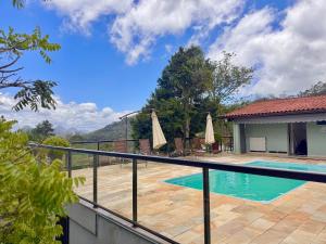 ein Haus mit einem Pool und einem Zaun in der Unterkunft Casa maravilhosa com piscina e sauna in Muri