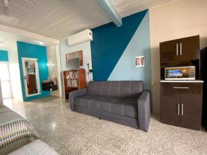 un salon avec un canapé et un mur bleu dans l'établissement Casa Magro depto para 6, à Oaxaca 28 autres photos