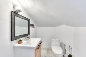 ein weißes Badezimmer mit Waschbecken und Spiegel in der Unterkunft Modern Comforts 3 Bedroom & Full Kitchen & Wifi & Easy Montreal Access in Longueuil