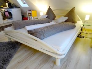ein weißes Sofa mit Kissen darauf im Zimmer in der Unterkunft Seeperle 1 in Meersburg
