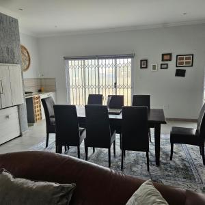 a living room with a dining room table and chairs at Atlantis in Hentiesbaai +3 photos