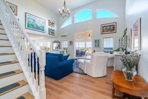 a living room with a blue couch and a staircase at Blue Ocean Cove Beach House in Saint Peters