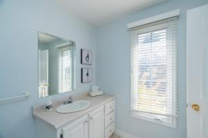 a white bathroom with a sink and a mirror at Blue Ocean Cove Beach House in Saint Peters +29 photos