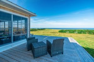 een terras met rieten stoelen en uitzicht op de oceaan bij Blue Ocean Cove Beach House in Saint Peters