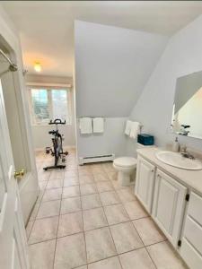 a white bathroom with a toilet and a sink at Blue Ocean Cove Beach House in Saint Peters