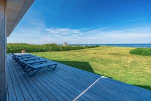 een rij banken op een terras met uitzicht op de oceaan bij Blue Ocean Cove Beach House in Saint Peters