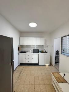 una cucina con mobili bianchi e un frigorifero di Best sea view a Qiryat Yam