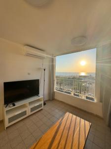un soggiorno con TV a schermo piatto e ampia finestra di Best sea view a Qiryat Yam