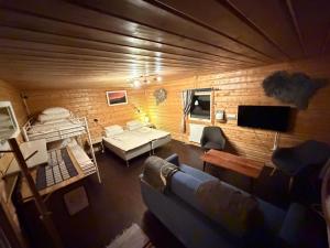 una sala de estar con un sofá y una cama en LAKESIDE AURORA CABINS, en Kiruna