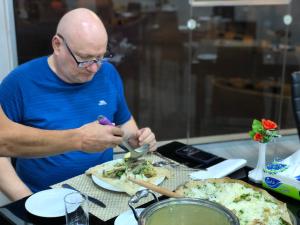 a man sitting at a table with a plate of food at Petra Rocks Hotel in Wadi Musa