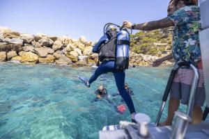 a man standing in the water with a dog in the water at Camping Begur - Luxe Lodge in Begur +3 photos