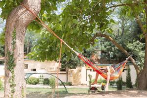 a girl is sitting in a hammock in a tree at Camping Begur - Luxe Lodge in Begur