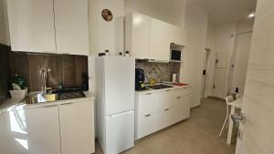 a kitchen with white cabinets and a white refrigerator at PETER PAN apartment in Salerno