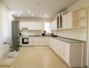 une cuisine avec des armoires blanches et un comptoir dans l'établissement Penzión Afrodita, à Čereňany