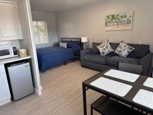 a living room with a couch and a bed at Barefoot Bay Resort Motel in Clearwater Beach