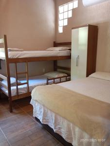 ein Zimmer mit drei Etagenbetten und einem Fenster in der Unterkunft Recanto Gira Cerrado in Cavalcante