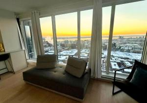 ein Wohnzimmer mit Couch und großem Fenster in der Unterkunft Altitude One - Skyline Residences Montreal in Montreal