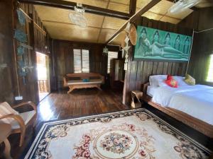 ein Schlafzimmer mit einem Bett und einem Teppich in einem Zimmer in der Unterkunft The Elephant House and Bungalows 