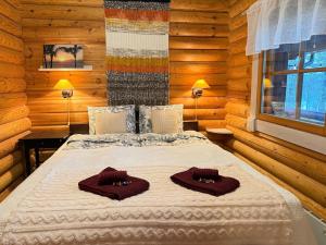 ein Schlafzimmer mit einem Bett mit zwei Handtüchern darauf in der Unterkunft Kantolammen mökki 66m2, kylpypalju ja puusauna in Kuusamo