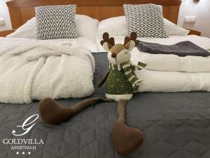 een opgezette rendier zit op een bed bij Goldvilla Apartman in Zalakaros