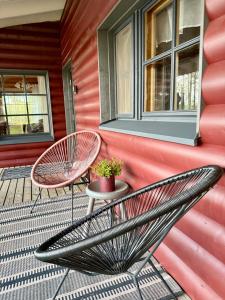 ein Paar Stühle auf einer Veranda in der Unterkunft Kantolammen mökki 66m2, kylpypalju ja puusauna in Kuusamo + 8 Fotos