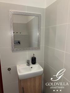 ein Badezimmer mit Waschbecken und Spiegel in der Unterkunft Goldvilla Apartman in Zalakaros