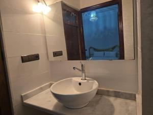 une salle de bains avec un lavabo blanc et un miroir dans l'établissement appartement chic, calme et bien équipé, à Meknès