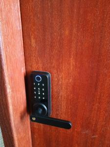 a remote control on a wooden door at Ap 2 quartos aconchegante com ar-condicionado in Viçosa