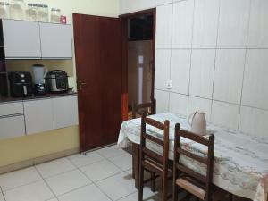 a kitchen with a table and chairs in a room at Ap 2 quartos aconchegante com ar-condicionado in Viçosa