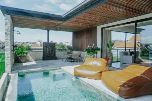 a house with a swimming pool and a patio at Villa Grazia Luxury Retreat Canggu in Canggu